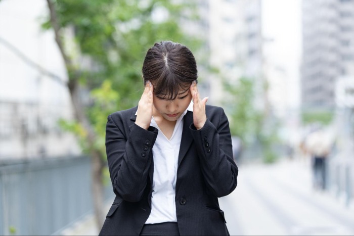 顎関節症による痛み、頭痛に悩む女性
